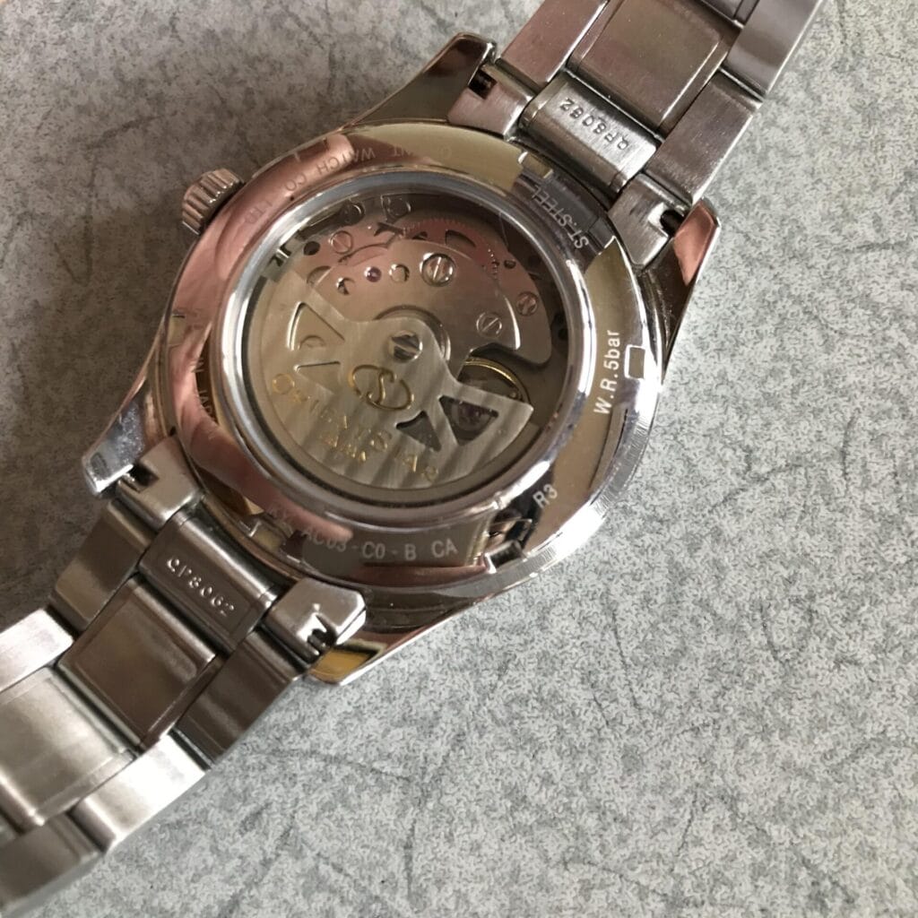 オリエントスター腕時計の裏側、ガラス越しにムーブメントが見える