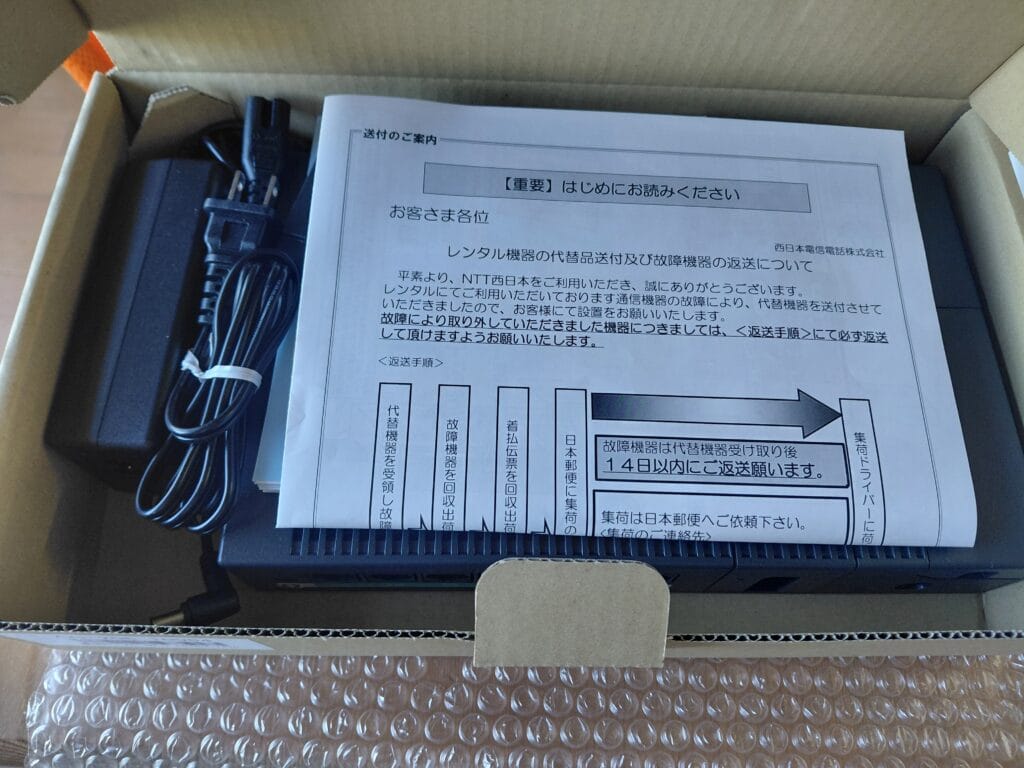 箱に入った新しいホームゲートウェイと「【重要】はじめにお読みください」という書類