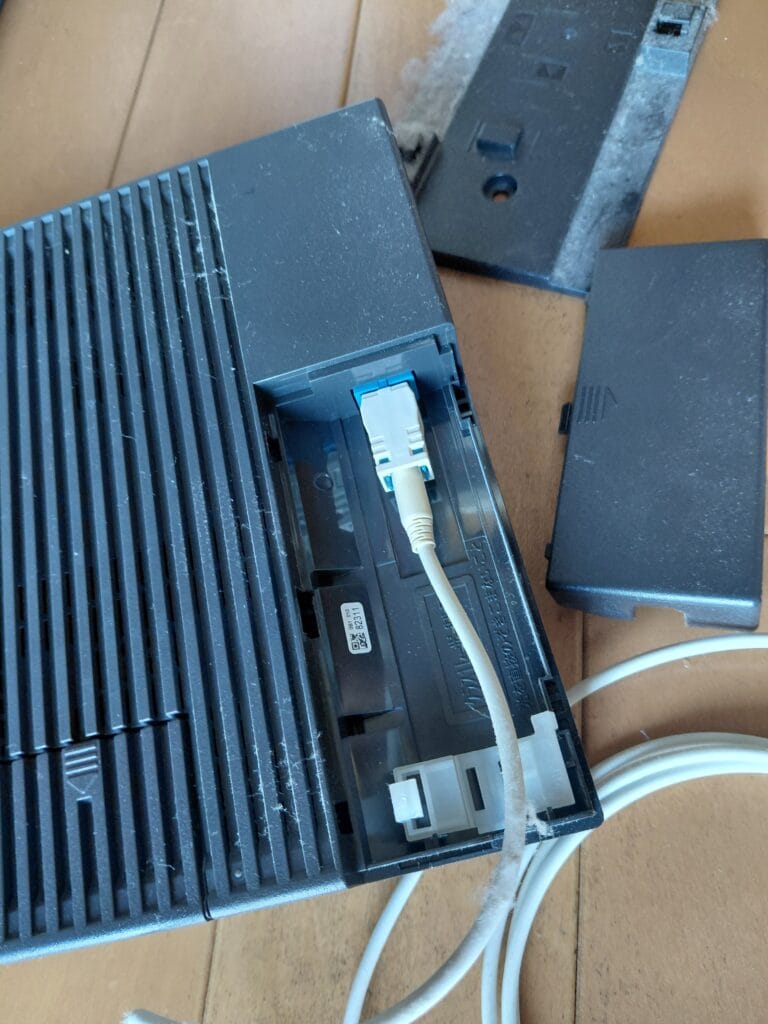 古いホームゲートウェイに光ファイバーケーブルが接続されている
